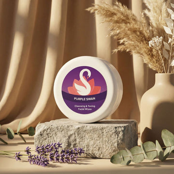 Container of Purple Swan cleansing and toning facial wipes on a stone surface with decorative elements.