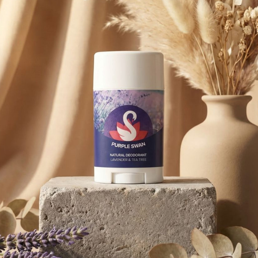 Purple Swan natural deodorant on a stone block with lavender and dried plants in the background