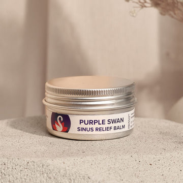Jar of Purple Swan sinus relief balm on a textured surface with a neutral background